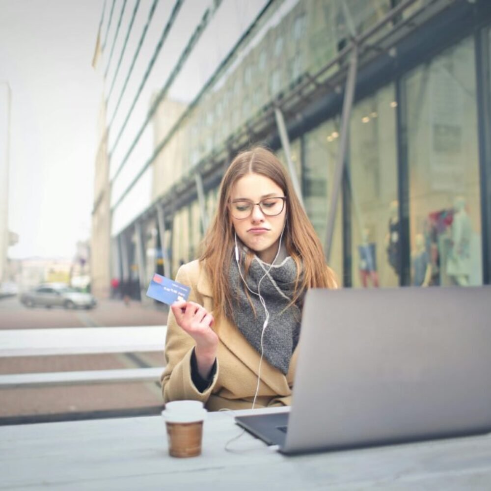 Woman in Brown Coat Holding a Bank Card
