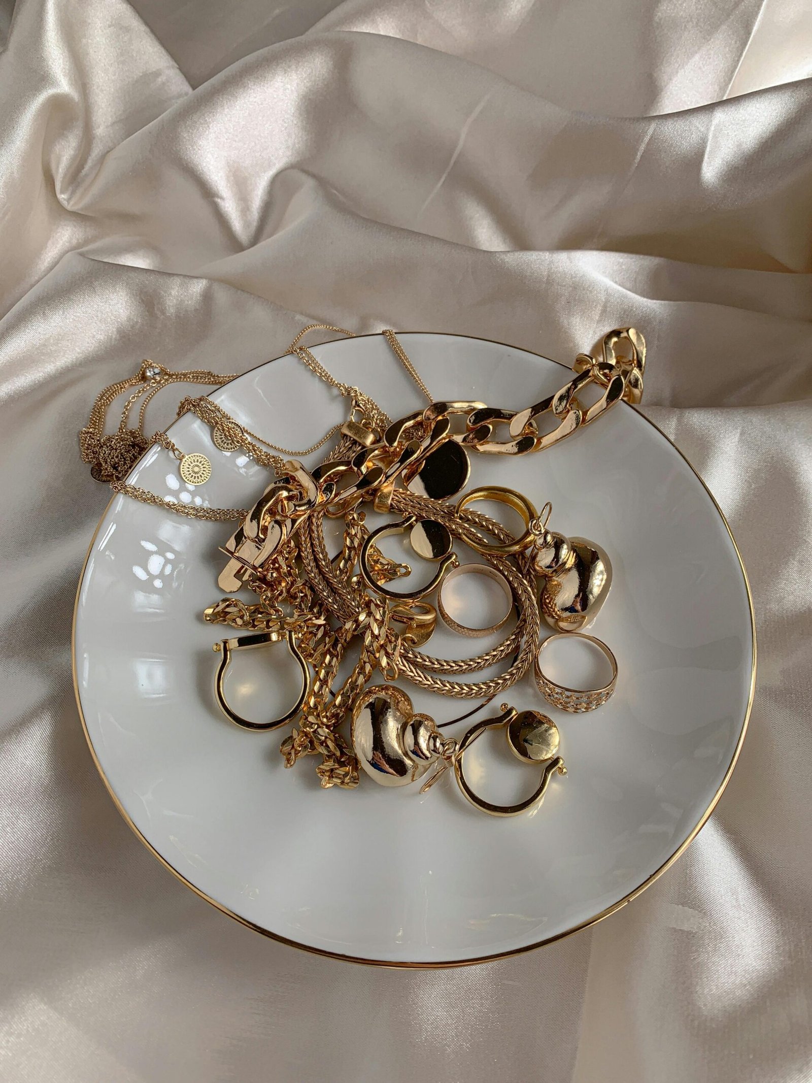 gold necklaces and rings in a white plate