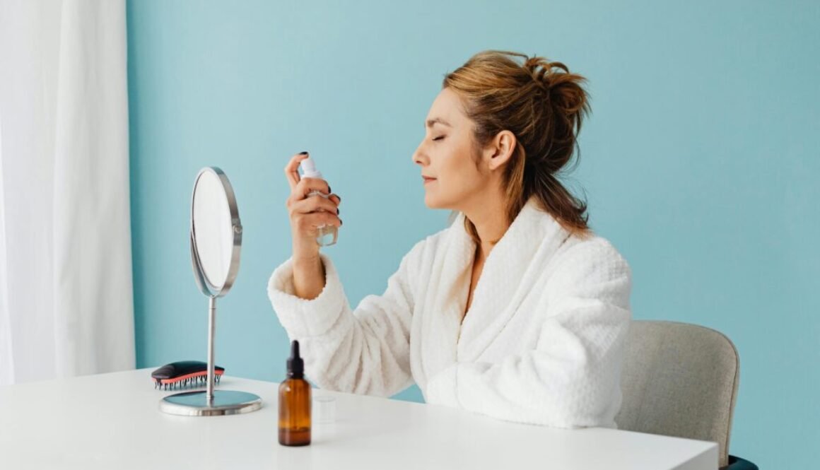 Lady looking at herself in the mirror while spraying her face