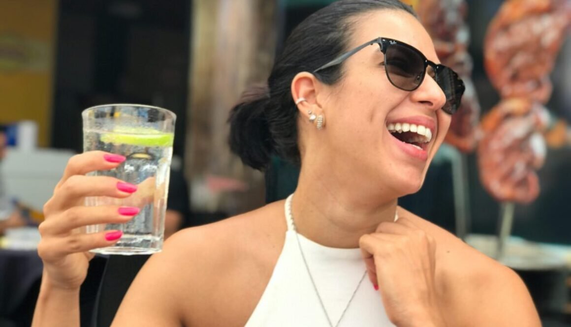 Lady laughing while holding a glass of water