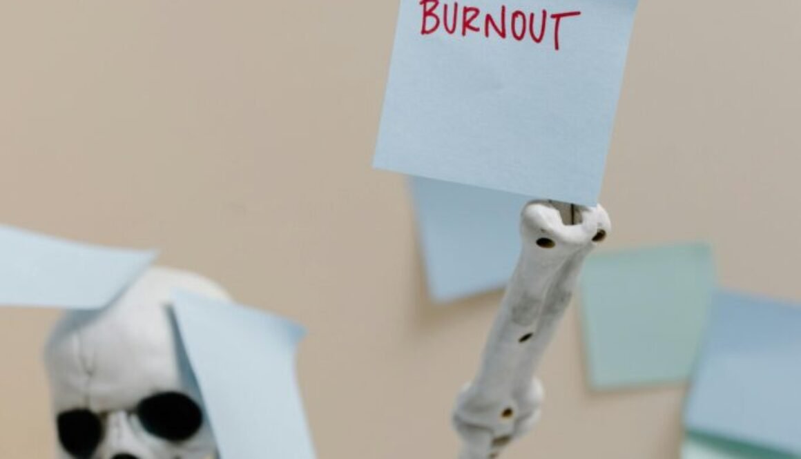 Skeleton holding a burnout sign, probably a corporate employee