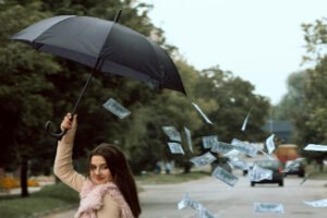 Money falling out of umbrella